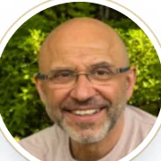 Roma Noam Buchimensky, smiling outdoors in front of greenery